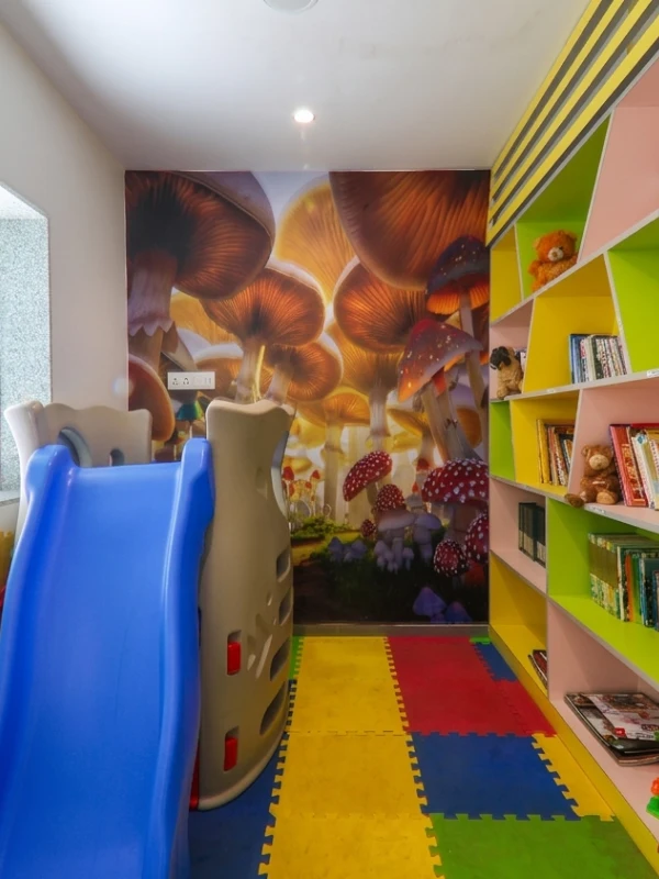 Kids Play Area – Family-Friendly Hotel in Panchgani Colourful kids play area with slide, books, and soft flooring at Orchid Hotel Panchgani for family stays