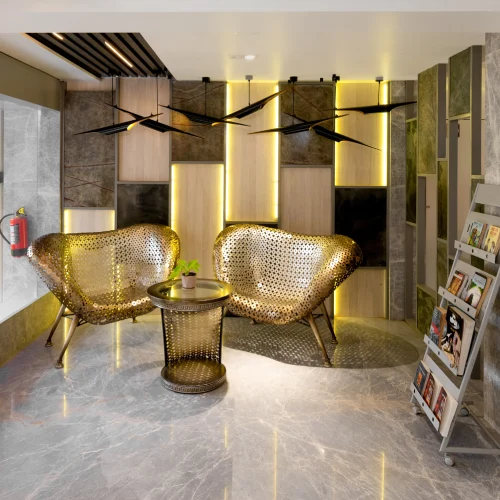 Designer Lobby – Orchid Hotel Panchgani Designer lobby with gold perforated chairs and ambient lighting at Orchid Hotel Panchgani