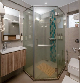 Dew Drop Mist Balcony Room Bathroom with Glass Shower - Panchgani Dew Drop Mist Balcony Room bathroom with glass shower enclosure and teal mosaic tiles at hotel in Panchgani