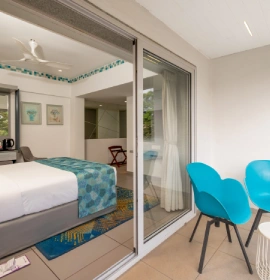 Dew Drop Mist Balcony Room with Balcony View - Hotel in Panchgani Dew Drop Mist Balcony Room view from balcony with queen bed and blue chairs at hotel in Panchgani