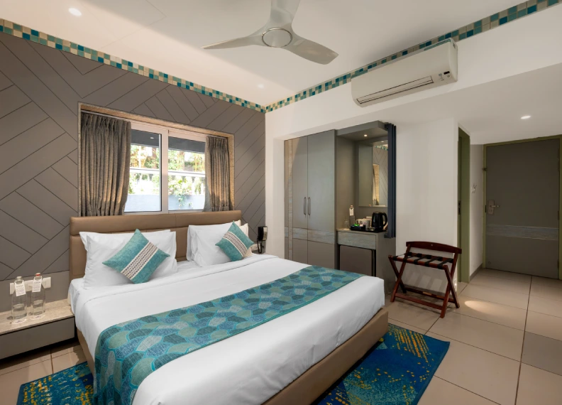 Dew Drop Deluxe Queen Room - Orchid Hotel Panchgani Dew Drop Room with queen bed, AC, ceiling fan and teal decor at Orchid Hotel Panchgani