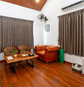 Tree House Suite Living Room - Orchid Hotel Panchgani Tree House Suite living area with leather sofa and wooden flooring at Orchid Hotel Panchgani