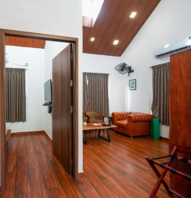 Tree House Suite Exterior - Orchid Hotel Panchgani Exterior view of Tree House Suite wooden cabin surrounded by tall eucalyptus trees at Orchid Hotel Panchgani