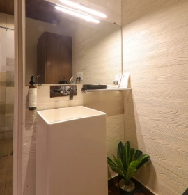 Wooden Cottage Suite Bathroom - Orchid Hotel Panchgani Modern bathroom with white vessel sink, beige textured tiles and glass shower in Wooden Cottage Suite Panchgani