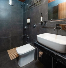 Tree House Suite Luxury Bathroom - Orchid Hotel Panchgani Modern bathroom with dark marble tiles, rainfall shower and vessel sink in Tree House Suite Panchgani