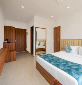 Wooden Tree House Bedroom with King Bed and Mirror - Panchgani Wooden Tree House bedroom with king bed, teal runner, full-length mirror and wooden wardrobe in Panchgani